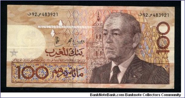100 Dirhams.

Older bust of King Hassan II at right, mosque in background on face; demonstration and coral at center on back.

Pick #65 (signature not reported) Banknote