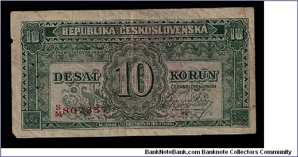 Republika Ceskoslovenska (Republic of Czechoslovakia) 10 Korun note of 1945 (P-60a). # S/M 807357. In circulated condition; one small tear on the left side, a slight vertical center fold, some spots. Three perforations down the left side of the note. Printed by Thomas de la Rue/London. 103mm x 53mm. Rare note sold to a British collector. Banknote